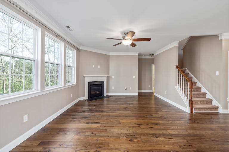 Bright and airy living room featuring wooden flooring and a fireplace.